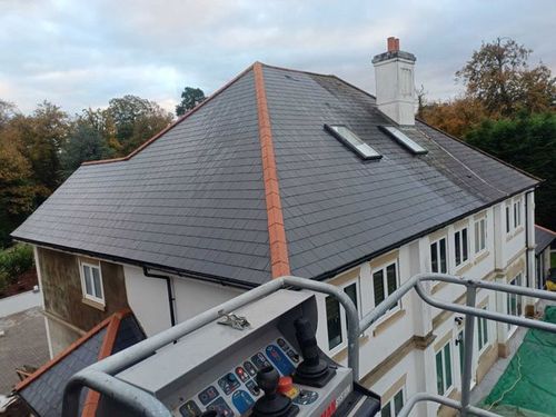 Freshly cleaned slate roof after professional washing using cherry picker